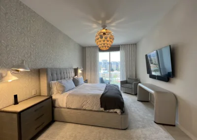 A bedroom with a bed, dresser and tv.