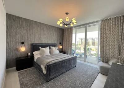 A bedroom with a large bed and a sliding glass door.