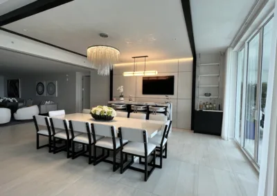 A modern dining room with a white table and chairs.
