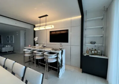 A modern dining room with white furniture and a tv.
