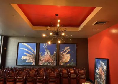 A room with chairs and a painting on the wall.